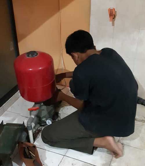 Teknisi profesional Garasi Teknik memeriksa mesin pompa air